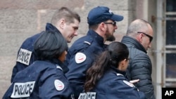 Former Kosovo prime minister Ramush Haradinaj (R) is rushed by police officers inside the Colmar courthouse, eastern France, Jan.5, 2017. 