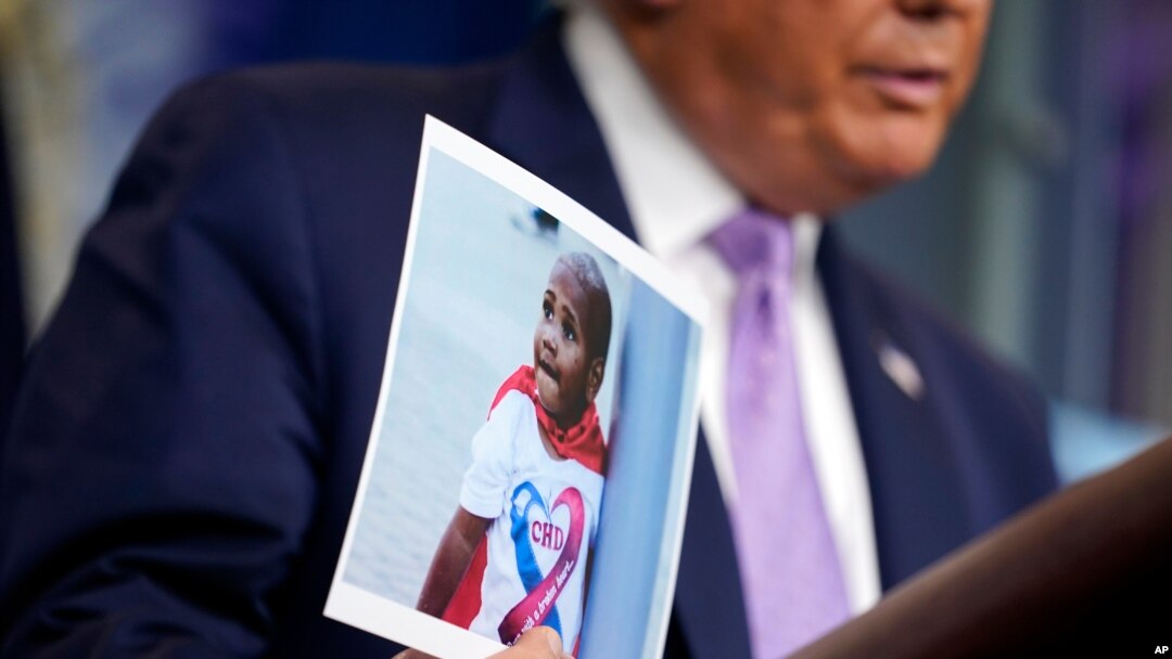 FILE - President Donald Trump holds a photo of LeGend Taliferro as he speaks at a news conference i at the White House, Aug. 13, 2020, in Washington.