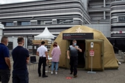 People queue for coronavirus tests at a medical tent in Sochi, Russia, Sept. 26, 2020.