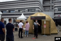 People queue for coronavirus tests at a medical tent in Sochi, Russia, Sept. 26, 2020.