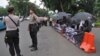 Indonesian police guard the Kamisan protesters, about 100 meters away from the Presidential Palace in Jakarta, Indonesia, July 13, 2017. 