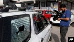 Afghan journalists films the vehicle in which director of Afghanistan's Government Information Media Center Dawa Khan Menapal was shot dead in Kabul, Afghanistan, Aug. 6, 2021.