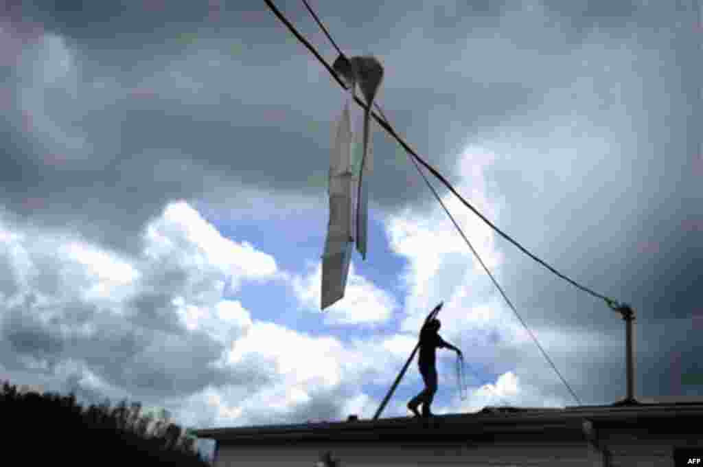 Metal siding hangs from a power line at a home Thursday, April 28, 2011 following a tornado in Glade Spring, Va. Several homes and trucks stops along I-81 were severely damaged near I-81. Five deaths have been reported. (AP Photo/Jeff Gentner)