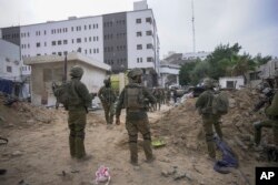 Tentara Israel berdiri di luar Rumah Sakit Shifa di Kota Gaza, Rabu, 22 November 2023. Israel mengatakan bahwa militan Hamas mencari perlindungan di halaman rumah sakit dan menggunakan terowongan itu untuk tujuan militer. (Foto AP/Victor R. Caivano)