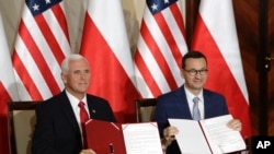 U.S. Vice President Mike Pence and Polish Prime Minister Mateusz Morawiecki display an agreement they signed in Warsaw, Poland, Monday, Sept. 2, 2019. The U.S. and Poland signed an agreement on Monday to cooperate on new 5G technology amid growing…