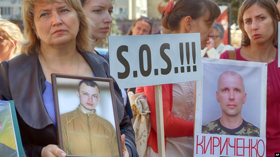 Relatives of the Ukrainian prisoners of war hold their portraits at a rally outside the German embassy in Kyiv, Ukraine, Sept. 14, 2016. 