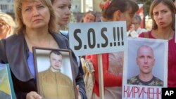 Relatives of the Ukrainian prisoners of war hold their portraits at a rally outside the German embassy in Kyiv, Ukraine, Sept. 14, 2016. 