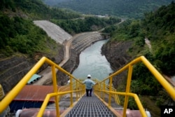 An employee walks down a stairway at Balambano hydroelectric plant, one of three dams that power PT Vale Indonesia's processing plant, in Sorowako, Indonesia. Vale churns out 75,000 tons of nickel a year for use in batteries and many other products. (AP Photo/Dita Alangkara)