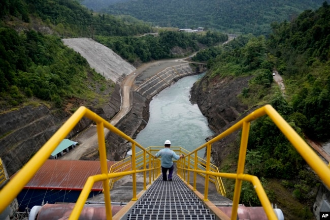 An employee walks down a stairway at Balambano hydroelectric plant, one of three dams that power PT Vale Indonesia's processing plant, in Sorowako, Indonesia. Vale churns out 75,000 tons of nickel a year for use in batteries and many other products. (AP Photo/Dita Alangkara)