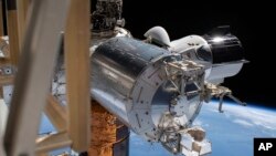SpaceX Crew Dragon, пристыкованный к Международной космической станции, во время выхода в открытый космос