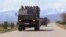 Ethnic Armenian fighters stand atop Kamaz military trucks passing through Martakert province in Azerbaijan's Armenian-administered region of Nagorno-Karabakh, April 4, 2016.