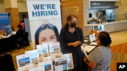 FILE - Marriott human resources recruiter Mariela Cuevas, left, talks to Lisbet Oliveros, during a job fair at Hard Rock Stadium, in Miami Gardens, Florida, Sept. 3, 2021.