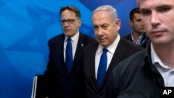 FILE - Israeli Prime Minister Benjamin Netanyahu, center, arrives with Cabinet Secretary Tzachi Braverman for a weekly Cabinet meeting at the prime minister's office in Jerusalem, April 29, 2018. 