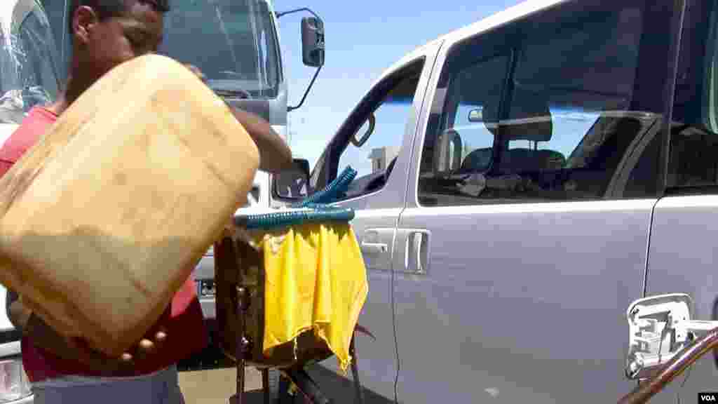 A Ben Guerdane resident filling a tank with Libyan oil. (L. Bryant/VOA)