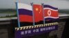 ILUSTRASI - Bendera Rusia (kiri), China (Tengah) dan Korea Utara (kanan) di menara pengamat di perbatasan antara tiga negara di Hunchun, provinsi Jilin di timur laut China, 25 Juni 2015. (GREG BAKER / AFP)