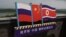 ILUSTRASI - Bendera Rusia (kiri), China (Tengah) dan Korea Utara (kanan) di menara pengamat di perbatasan antara tiga negara di Hunchun, provinsi Jilin di timur laut China, 25 Juni 2015. (GREG BAKER / AFP)