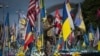 FILE - A volunteer soldier of the Ukrainian Foreign Legion takes a video at a makeshift memorial for fallen Ukrainian and foreign soldiers on Independence Square in Kyiv, Ukraine, July 23, 2024.