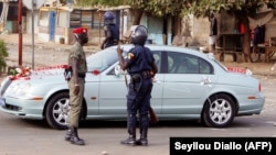 Une voiture de mariés stoppée par un policier lors d'une manifestation contre la vie chère à Dakar le 30 mars 2008.