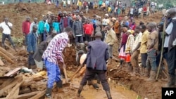 Rescue workers and people search for bodies after landslides following heavy rains buried 40 homes in the mountainous district of Bulambuli, eastern Uganda, Nov. 28. 2024.