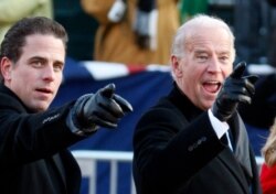 FILE - U.S. Vice President Joe Biden, right, and his son Hunter point to some faces in the crowd as they walk down Pennsylvania Avenue following the inauguration ceremony of President Barack Obama in Washington, Jan. 20, 2009.