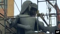 Egypt Offensive Sculpture: A sculpture, titled “Mother of the Martyr,” depicts a slender peasant woman, a traditional artistic representation of Egypt, with her arms outstretched with a helmeted soldier standing behind her, at a public square in Sohag, Eg