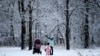 A woman plays with a child in Moscow's Tushino park after a snowfall.