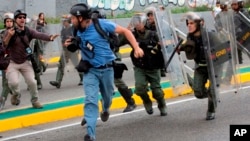 El reportero fotográfico de Reuters, Marco Bello, corre mientras los soldados de la Guardia Nacional venezolana lo persiguen durante una protesta frente a la Corte Suprema en Caracas, Venezuela, el 31 de marzo de 2017.