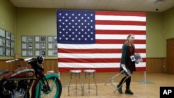 Una mujer, parte del personal de la campaña del candidato presidencial demócrata estadounidense Bernie Sanders, Mueve sillas antes de un evento de campaña.