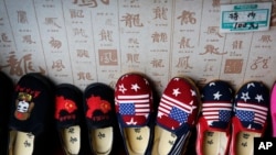 ເກີບຂອງເດັກນ້ອຍ ທີ່ມີຮູບທຸງຊາດຂອງຈີນ ແລະ ສະຫະລັດ ທີ່ຜະລິດໂດຍຈີນ ໄດ້ຖືກວາງສະແດງ ເພື່ອການຈຳໜ່າຍ ຢູ່ທີ່ຮ້ານຄ້າແຫ່ງນຶ່ງ ໃນ ນະຄອນຫຼວງປັກກິ່ງ ຂອງຈີນ, ວັນທີ 13 ກໍລະກົດ 2018.