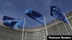 European Union flags flutter outside the European Commission headquarters in Brussels, April 20, 2021.