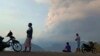 Residents watch as Mount Lewotobi Laki Laki volcano spews volcanic materials during an eruption in East Flores, Indonesia, Nov, 9, 2024.