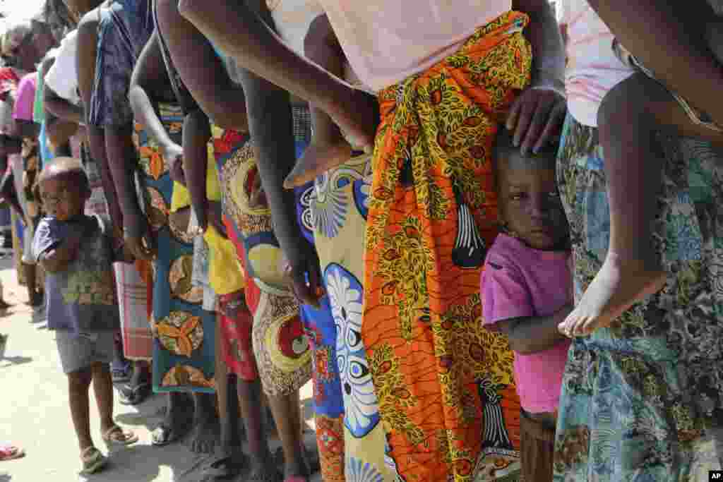 Perempuan dan anak-anak antri untuk mendapatkan vaksinasi kolera di kamp penampungan para penyintas topan Idai di Beira, Mozambik.