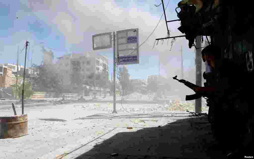 A Syrian rebel fighter runs for cover after a heavy explosion in the Seif El Dawla district of Aleppo city August 22, 2012. 