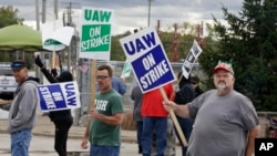 John Kirk, right, a 20-year-employee, pickets with co-workers outside the General Motors Fabrication Division, Oct. 4, 2019, in Parma, Ohio. 