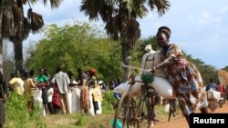 A refugee from South Sudan transports food she received from the World Food Program (WFP) in Palorinya settlement camp for distribution, in Moyo district northern Uganda, Oct. 26, 2017.