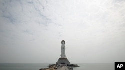 Tourists walk towards a 108-meter high Buddhist statue at Nanshan Cultural Center, about 60km (37 miles) west of Sanya, in south China's Hainan Island province. (file photo)