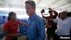 Chip Starnes, president of Florida-based Specialty Medical Supplies, returns to the room where he is being detained as factory workers block journalists trying to follow him after his news conference at the company's factory on the outskirts of Beijing Ju