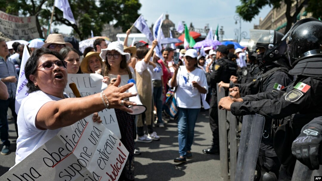 A woman confronts police officers as employees of the Judiciary, who are on an indefinite strike, protest in front of the Supreme Court of Justice in Mexico City on August 25, 2024.