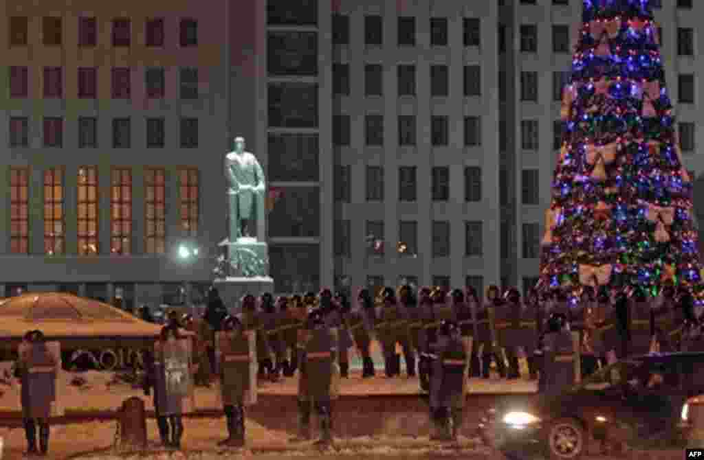 Riot police block the square in front of the government building in Minsk, Belarus, early Monday, Dec. 20, 2010. Thousands of opposition supporters in Belarus tried to storm the main government building to protest what the opposition claims was large-scal