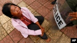 A Boeung Kak lake protester cries as she confronts a line of riot police officers during a protest rally against land eviction near the prime minister's residence, in Phnom Penh, Cambodia, July 2, 2013.