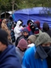 Migranti iz Venecuele stoje u redu po hladnom vremenu za topli napitak i hranu od volontera u improviziranom kampu na američko-meksičkoj granici u Matamorosu, Meksiko, 23. decembra 2022.