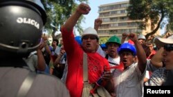 FILE - Mining workers of Doe Run Peru protest in front of the Labor Ministry in Lima to demand that Peru's government save their jobs at the shuttered La Oroya metals smelter in the Andes, April 19, 2012.