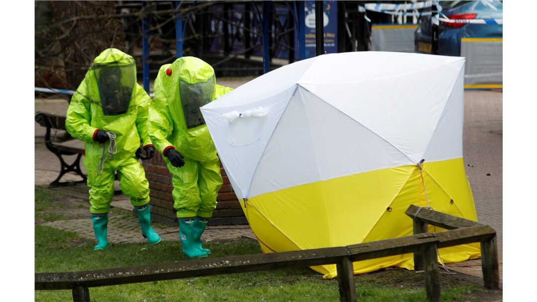 FILE - The forensic tent, covering the bench where Sergei Skripal and his daughter Yulia were found, is repositioned by officials in protective suits in the center of Salisbury, Britain, March 8, 2018.
