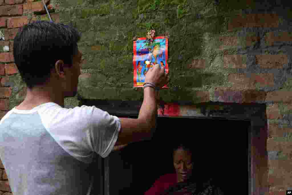 A Nepalese man displays a machine made painting on his house door during Naag Panchami festival in Bhaktapur, Nepal, Aug. 5, 2019.