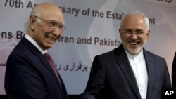 Iranian Foreign Minister Mohammad Javad Zarif, right, shakes hands with former Pakistan's adviser on foreign affairs Sartaj Aziz in Islamabad, Pakistan, March 12, 2018.