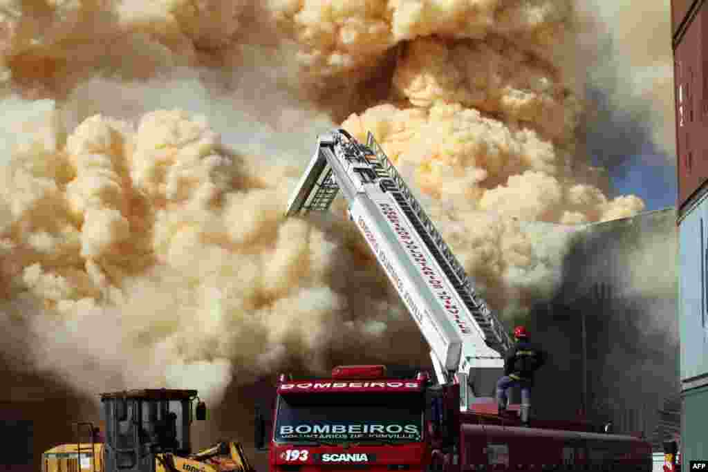 Firefighters try to extinguish a fire at a fertilizer depot in Sao Francisco do Sul, Santa Catarina, Brazil. The dense smoke, produced by ammonium nitrate at the building, forced to evacuate more than 150 families.