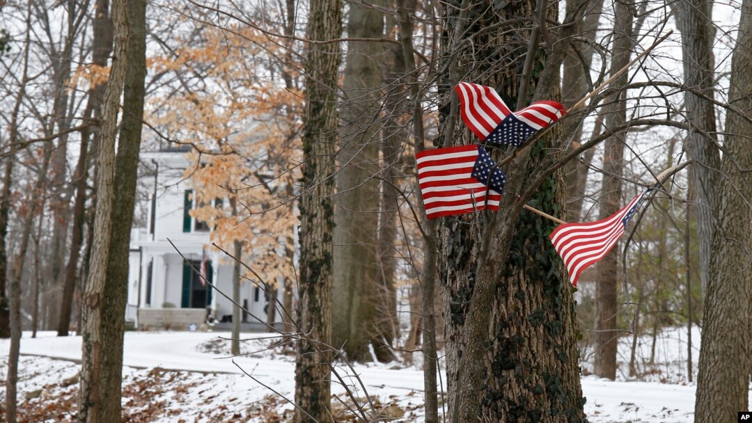 Beberapa bendera Amerika berukuran kecil dipasang di sebuah pohon di depan rumah keluarga Otto Warmbier, di Wyoming, Ohio, Jumat (22/1). Warnbier, mahasiswa AS dikabarkan ditahan oleh pihak berwenang Korea Utara.