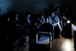 In this handout photo released by the Armenian Foreign Ministry on Monday, Sept. 28, 2020, people watch the State TV as they gather in a bomb shelter to protect against the shelling in Stepanakert, the self-proclaimed Republic of Nagorno-Karabakh.