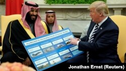 Presiden AS Donald Trump memegang informasi perlengkapan militer AS yang dijual kepada Saudi Arabia dalam pertemuan dengan Putra Mahkota Mohammed bin Salman di Gedung Putih, Selasa (20/3). 