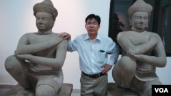 Kong Vireak, the director of the National Museum of Cambodia, with two of the returned statues known as the Kneeling Attendants, Phnom Penh, June 30, 2014. (Robert Carmichael/VOA) 
